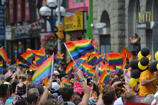 People waving rainbow flags at a parade