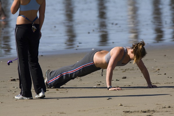 Young women exercising on a beach